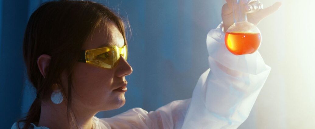 Laborantka trzymająca kolbę z płynem