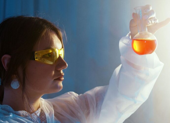 Laborantka trzymająca kolbę z płynem