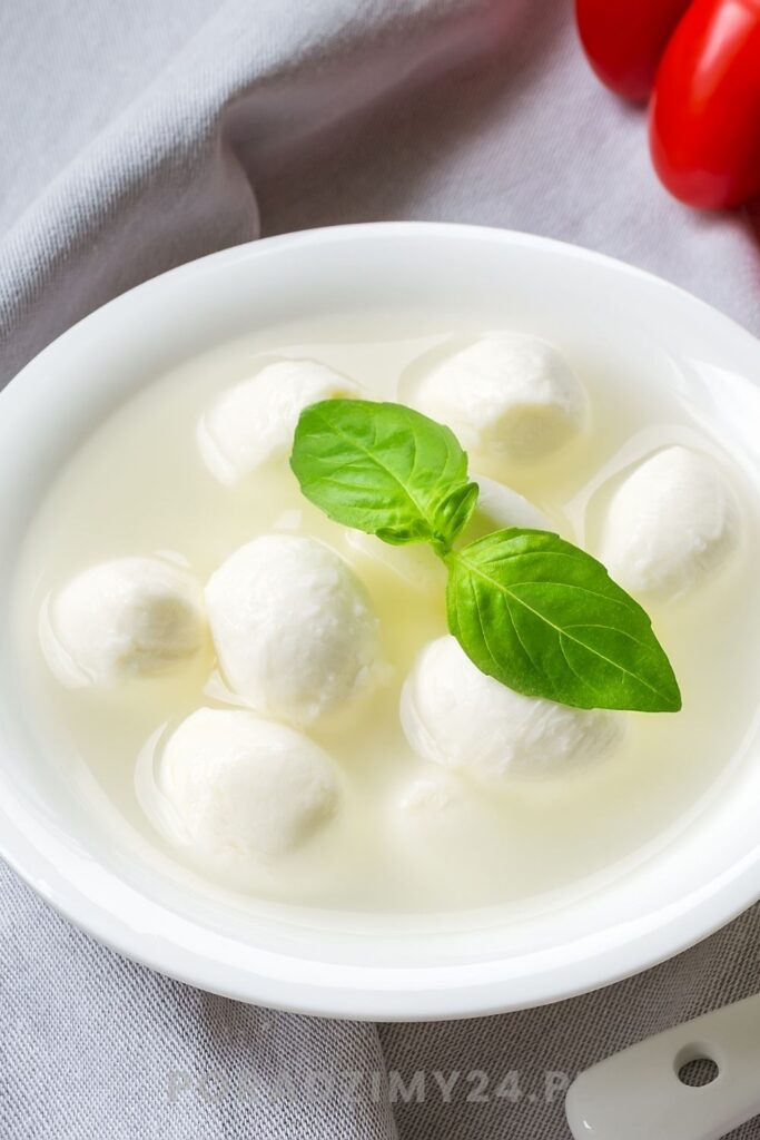 Kulki mozzarelli w zalewie, udekorowane świeżą bazylią