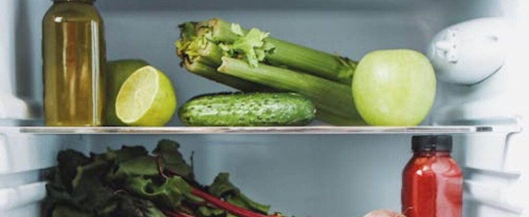 Ogórek na półce w lodówce obok selera naciowego, cytryny i cebuli