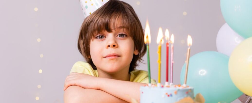 Chłopiec świętuje urodziny przy torcie ze świeczkami