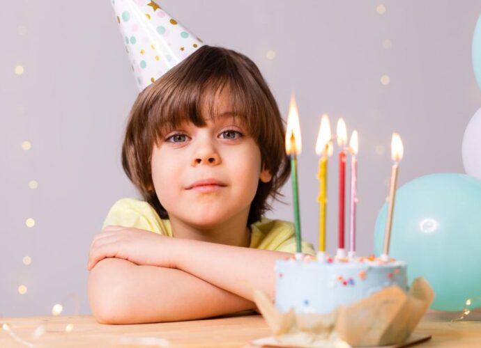 Chłopiec świętuje urodziny przy torcie ze świeczkami