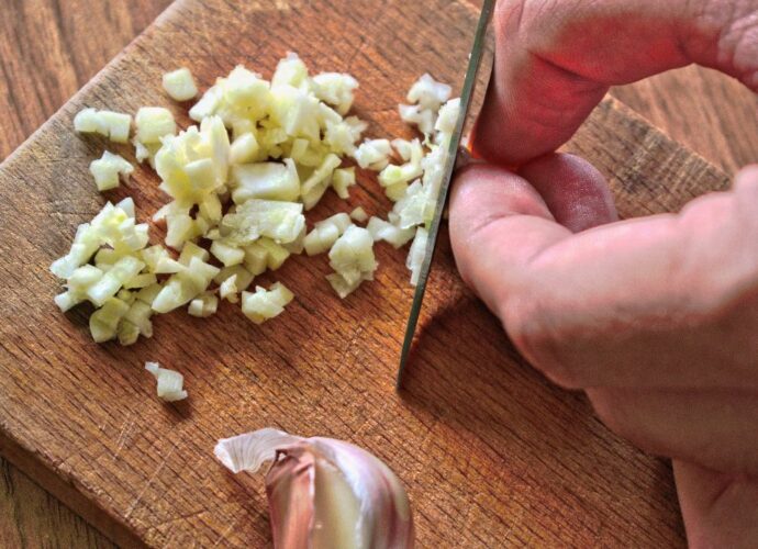 Krojenie świeżego czosnku na drewnianej desce