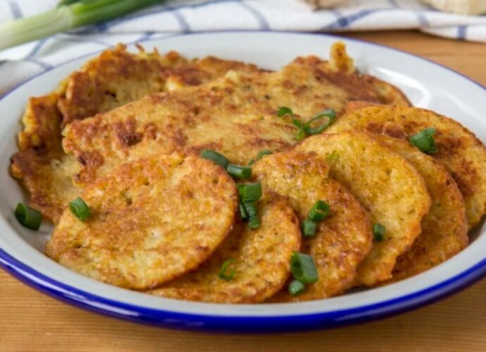 Chrupiące placki ziemniaczane posypane posiekaną cebulką dymką