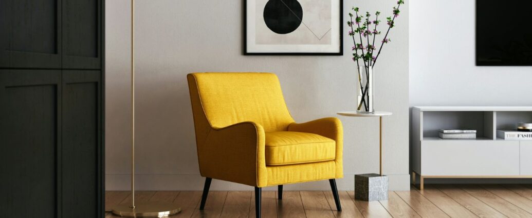 Nowocześnie urządzone nowe mieszkanie, w centralnej części pokoju stoi żółty fotel