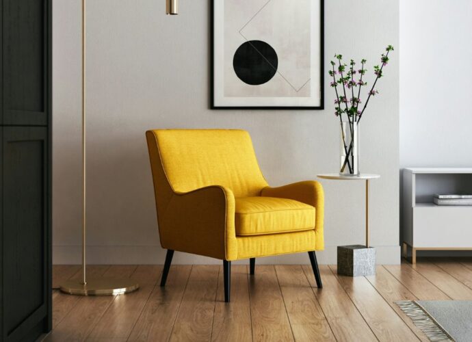 Nowocześnie urządzone nowe mieszkanie, w centralnej części pokoju stoi żółty fotel